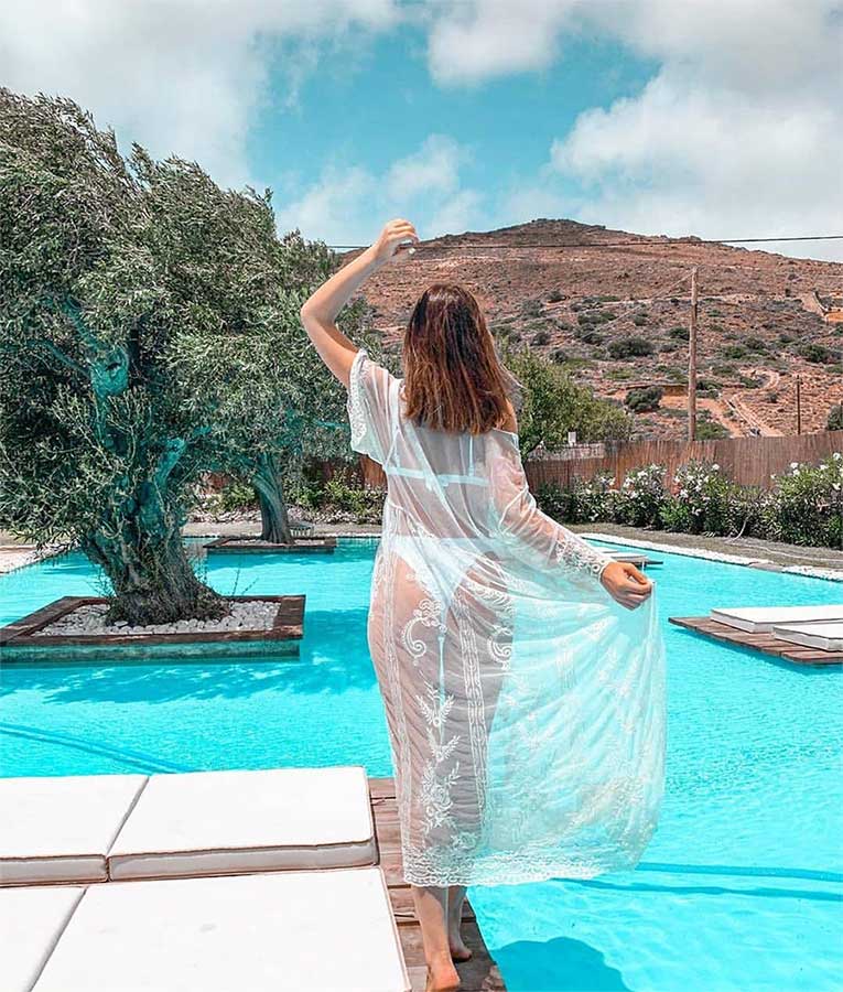Guest in a lace dress overlooking the pool and Andros hills