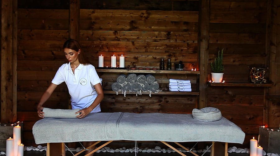 Therapist preparing the massage table by candlelight