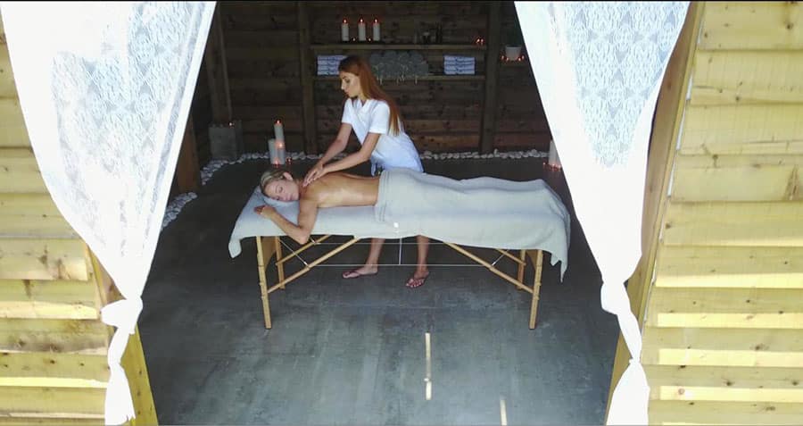 Massage treatment inside the wooden wellness cabin